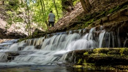 Person walking above a waterfall