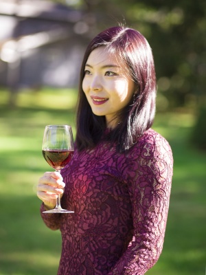 Jie Li poses with a glass of wine