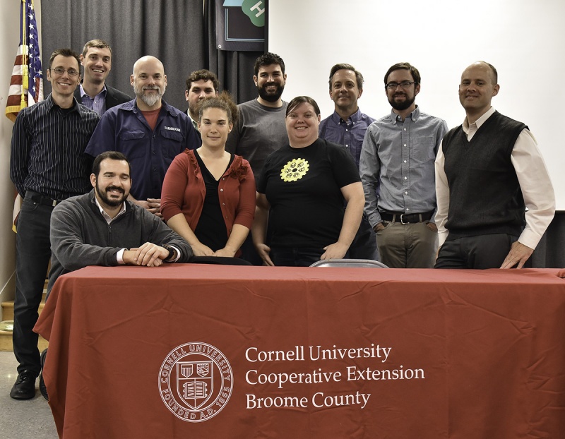 Summit attendees stand with a Cornell University Cooperative Extension Boome County sign