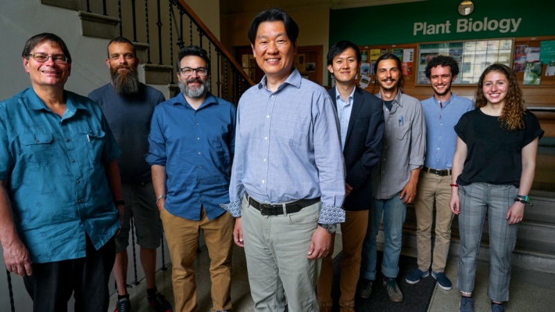 Eight researchers, including students and faculty, stand in a hallway