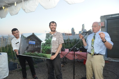 Three men presenting a photo