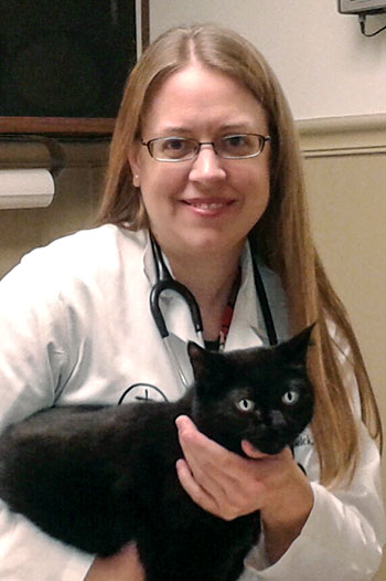 A woman holds a black cat