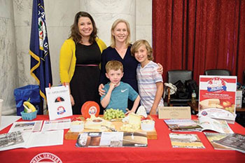 Two women and two children stand behind a booth