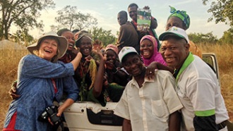 A group of people stand together for a photo in a field