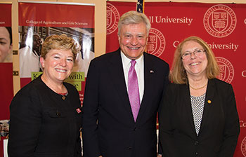 Two women and a man stand together for a group photo