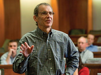A man speaking in front of a room full of people