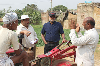 Four men stand outside and speak together