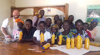 A group of people stand together in front of bottles of juice
