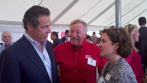 Three people stand together and talk