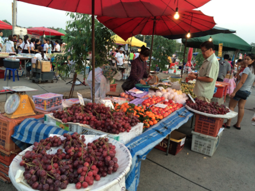 A man buys produce from a street vendor in Thailand