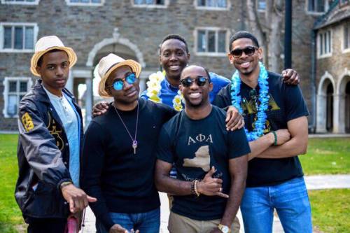 A photo of five men standing together at a fraternity event