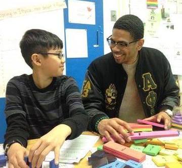 A college student volunteering with an elementary school student