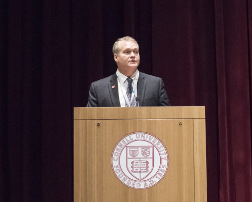 A man speaks at a podium at a conference
