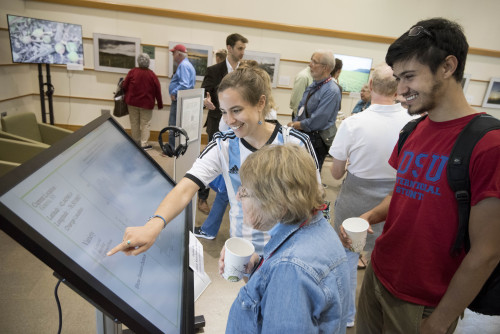 A group of people look at an exhibit on how farms are adapting to climate change