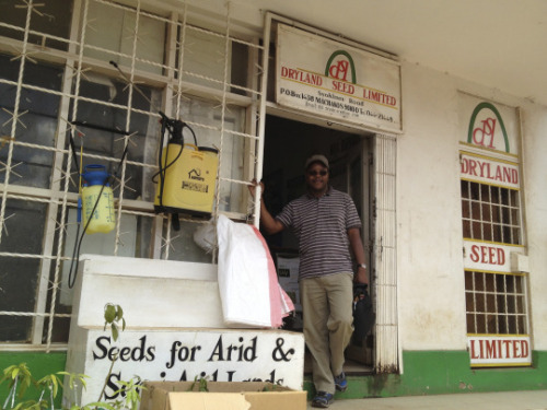 A man stands in front of a seed store in Kenya
