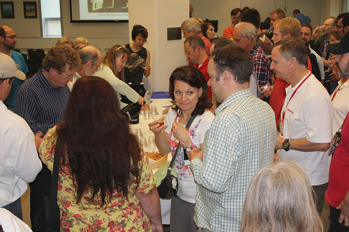 A group of people stand together and drink beer from plastic cups