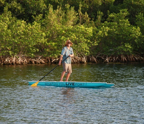 A man paddle boards on the water