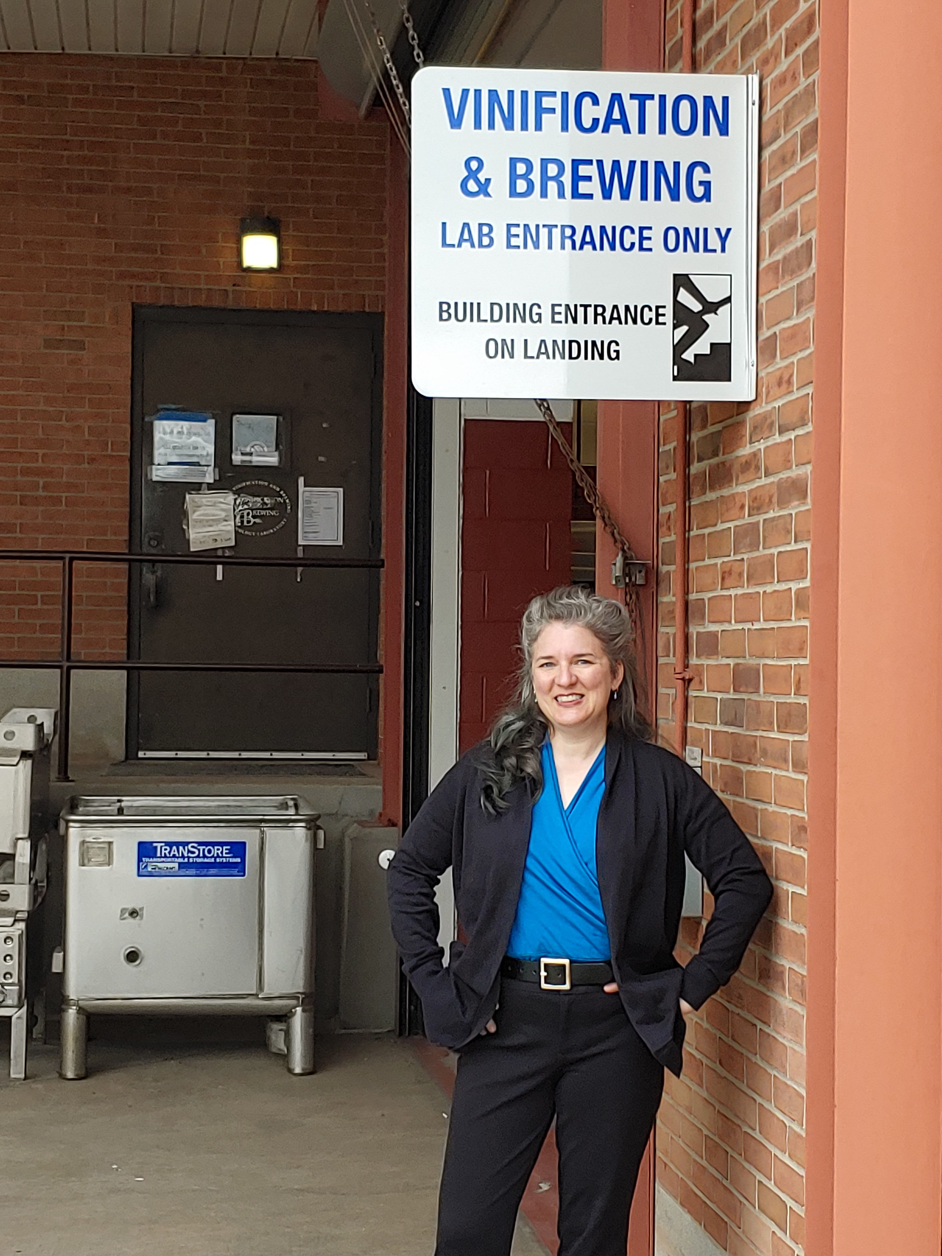 a woman stands outside the vinification and brewing lab entrance