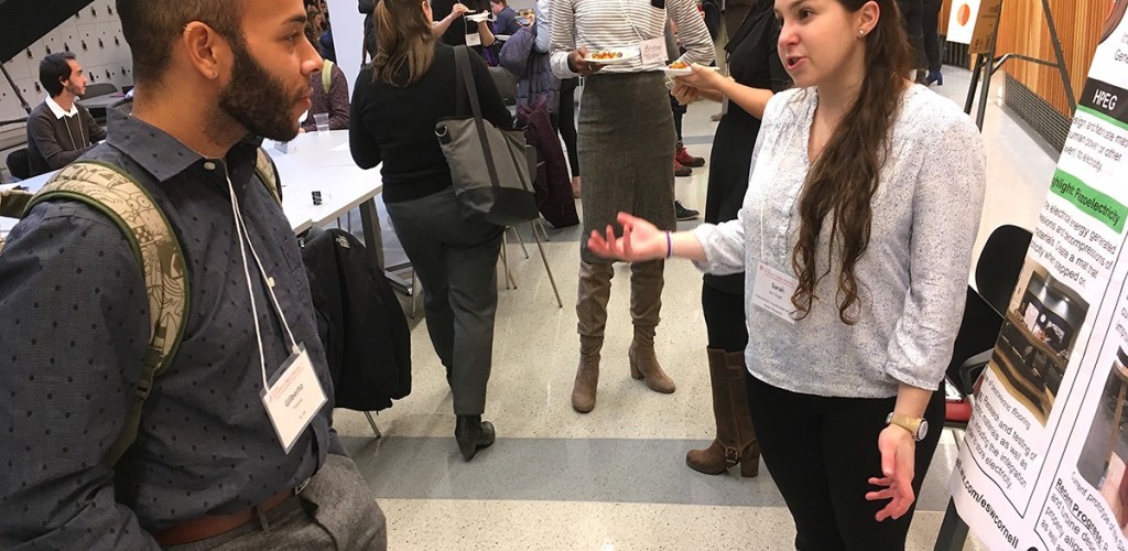 Gilberto Trevino listens to Sarah Barr Engel discuss wind energy at the poster session at the Cornell Business Impact Symposium
