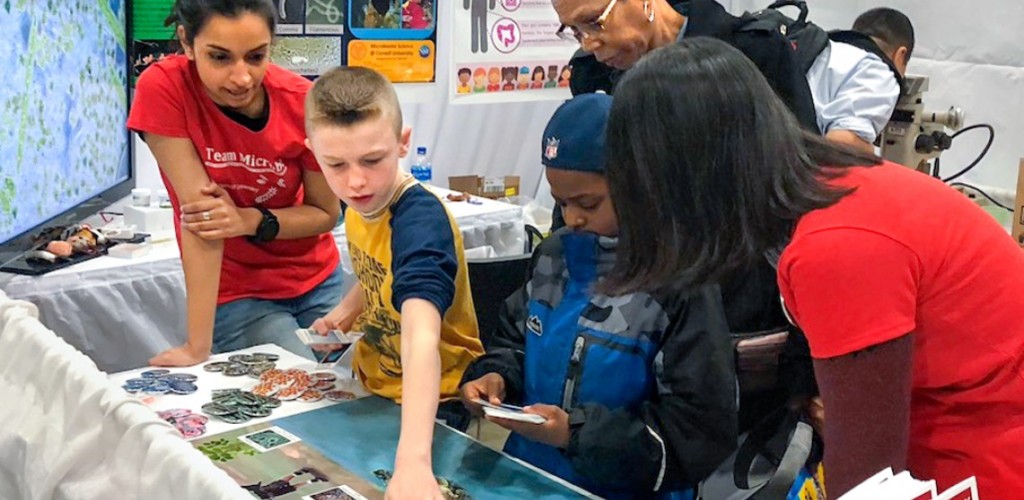 Cornell students interact with young students at table