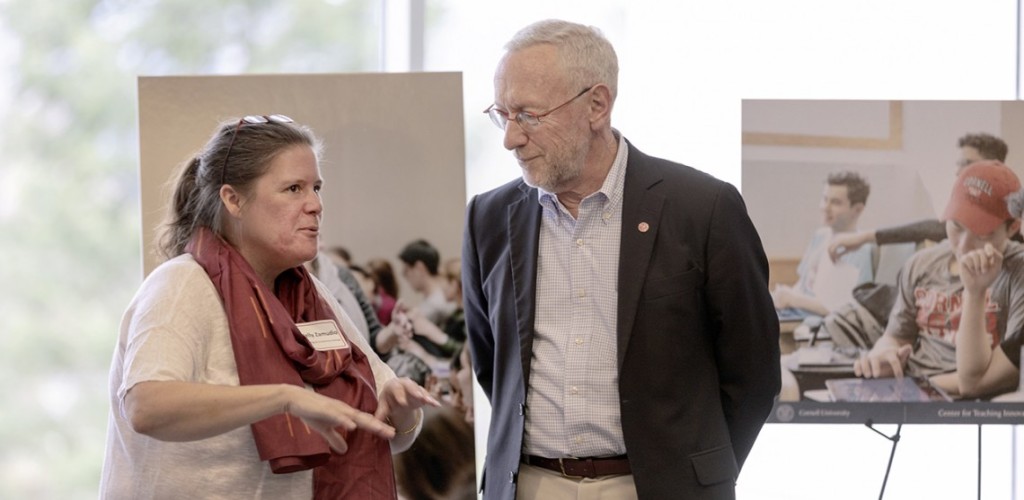 Kelly Zamudio and Provost Michael Kotlikoff talk in front of images on easels