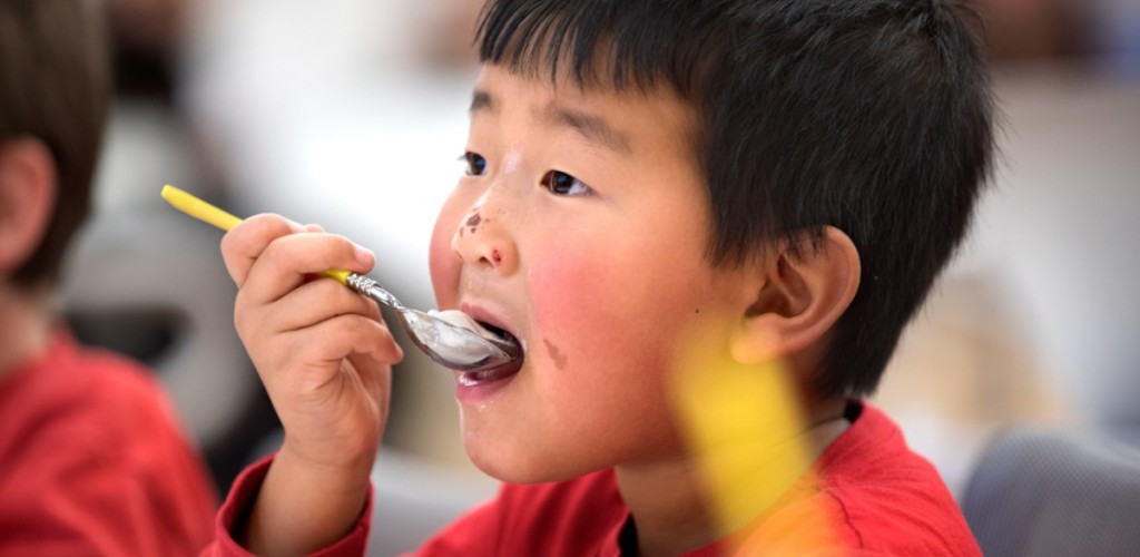 Child eats ice cream with a spoon