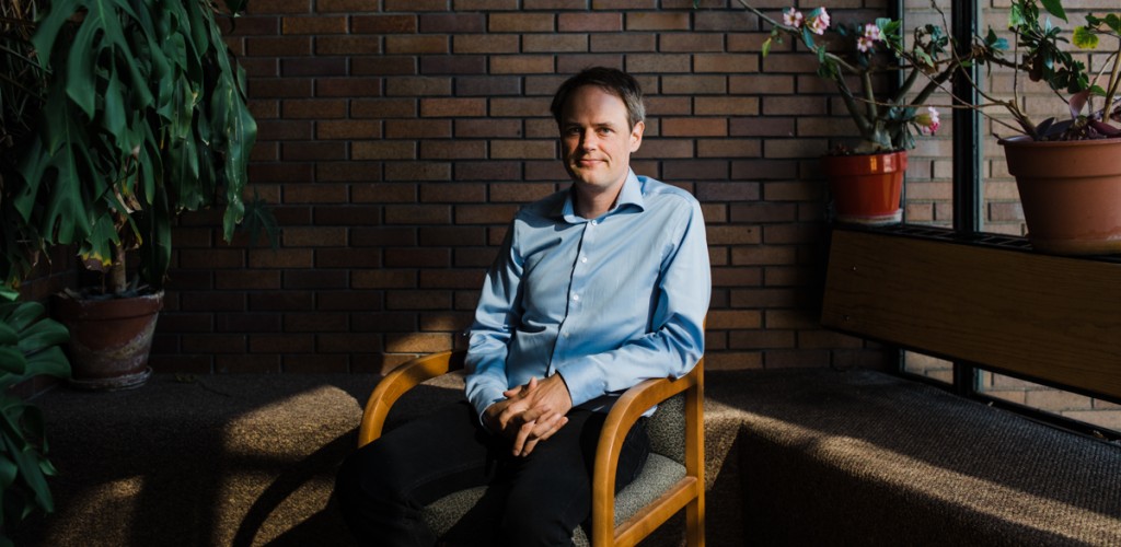 Peter Hitchcock sits in a chair on campus