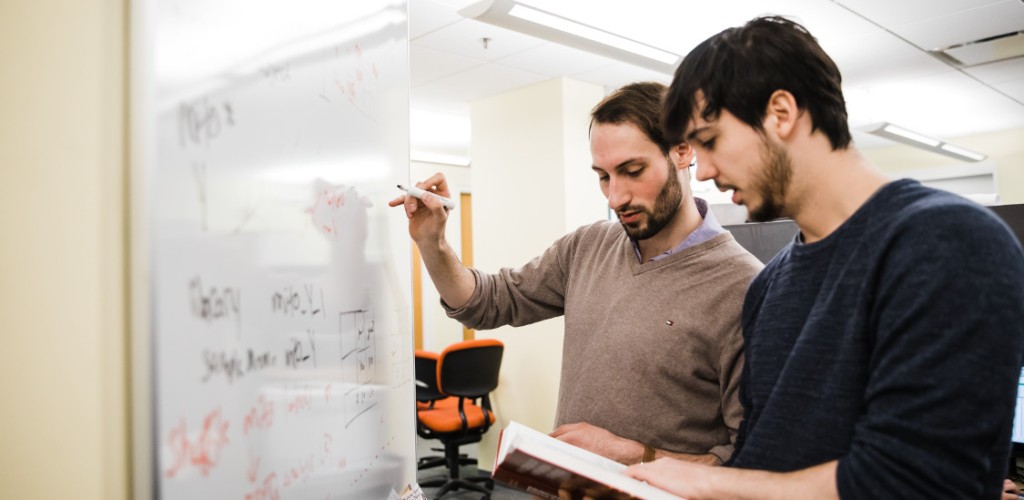 Students writing on a white board