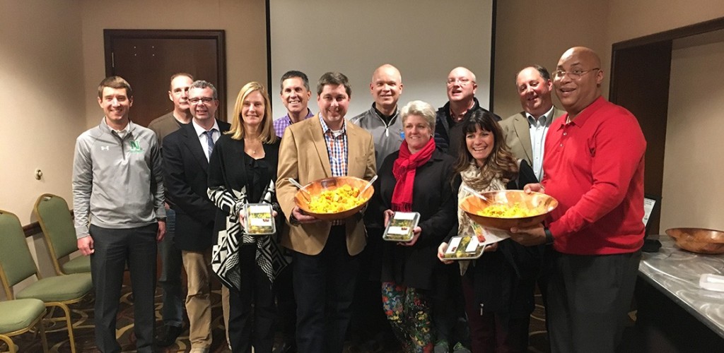Volunteers standing with food they prepared