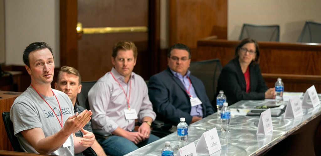 researcher speaks at panel while others listen