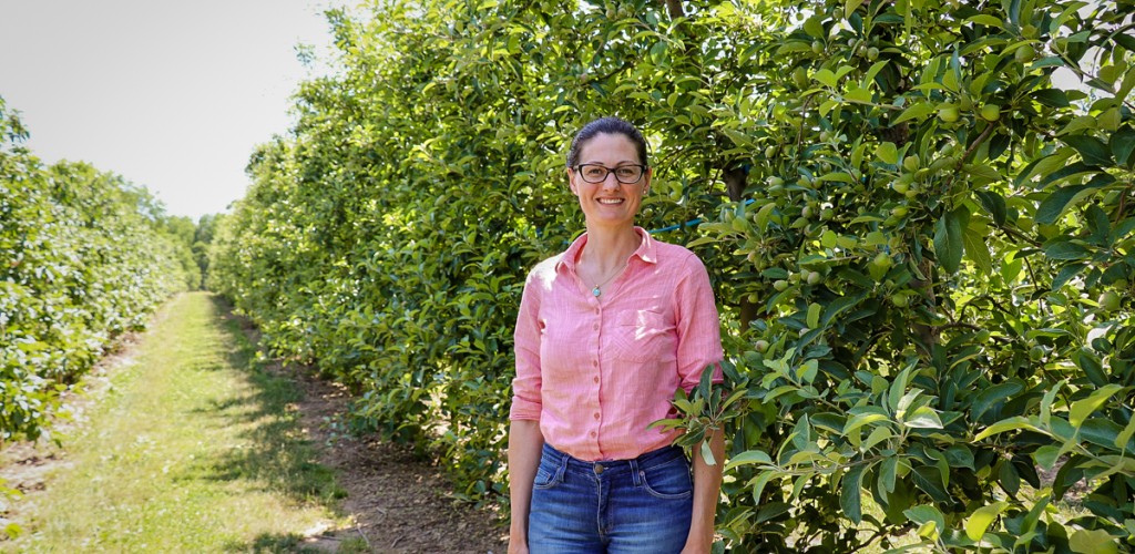 Poliana Francescatto stands in a orchard