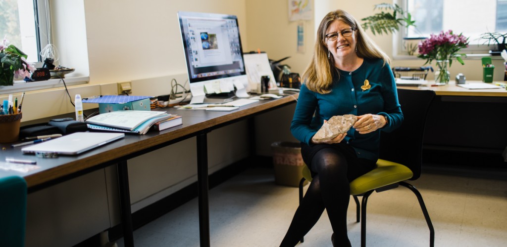 Maria Gandolfo in her office holding a fossil