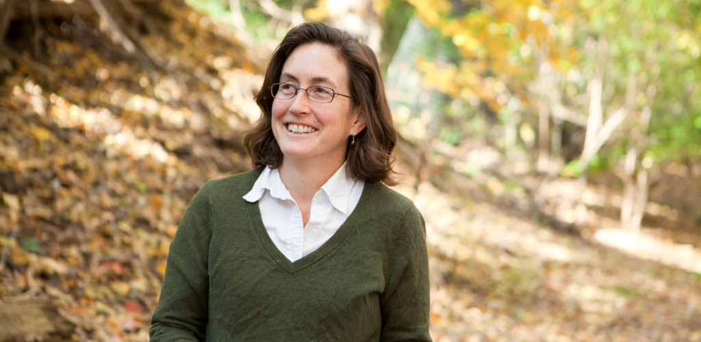 natalie mahowald stands in a forest holding leafs