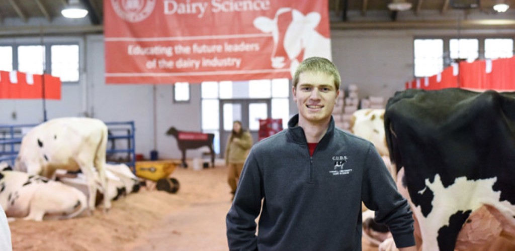 Conor McCabe stands in the Cornell University Dairy Barn