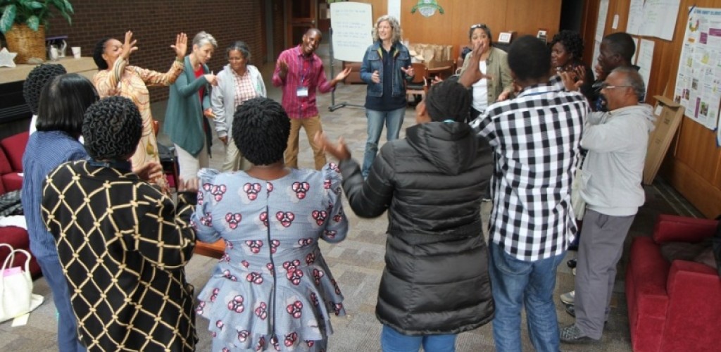 Members of the collaboratory dance in a circle