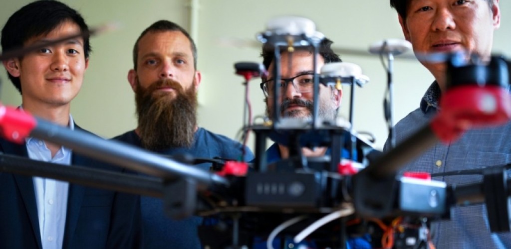 A drone appears in front of four male researchers