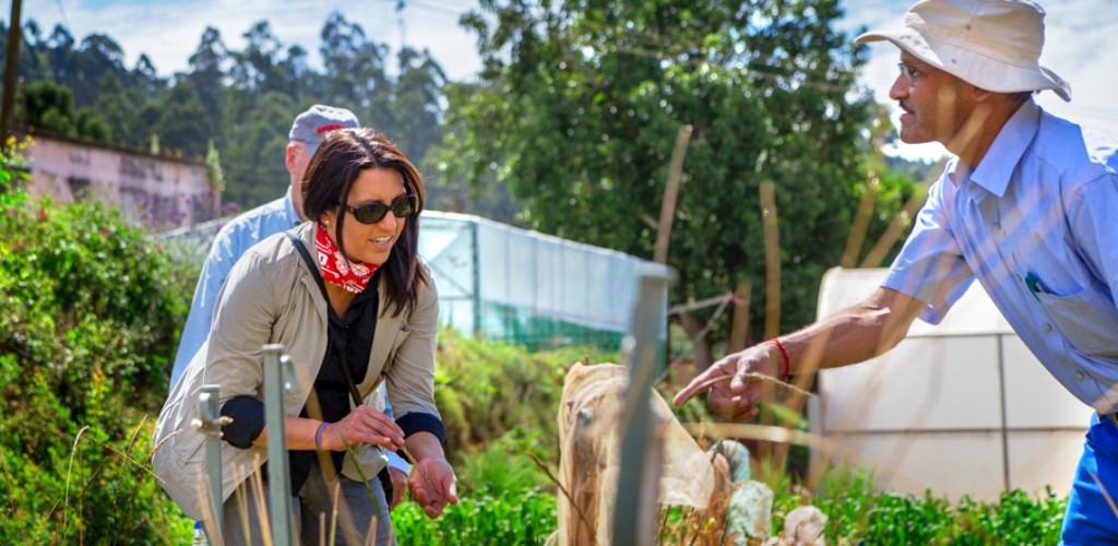 A woman speaking with a man in a garden 