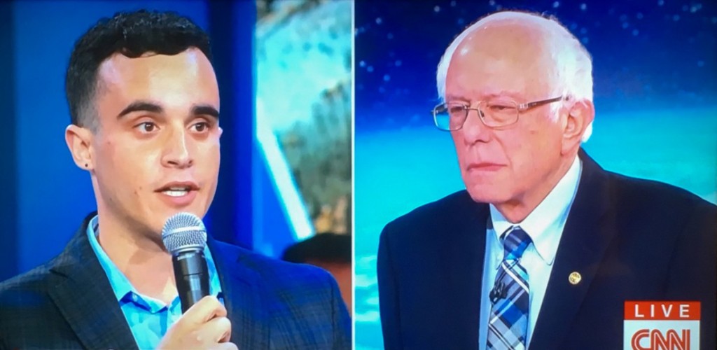 A split screen of a male student holding a microphone asking a question of a male presidential candidate 