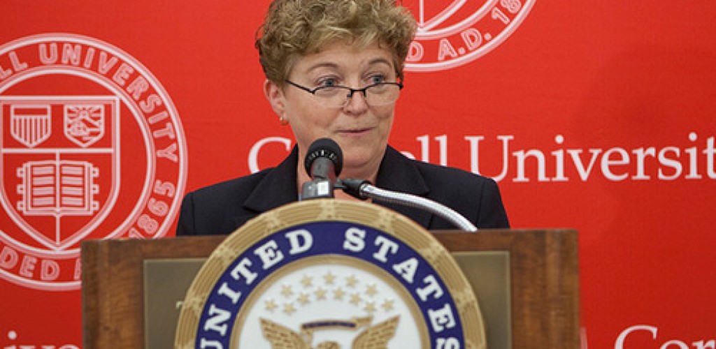 A woman stands at a podium and speaks