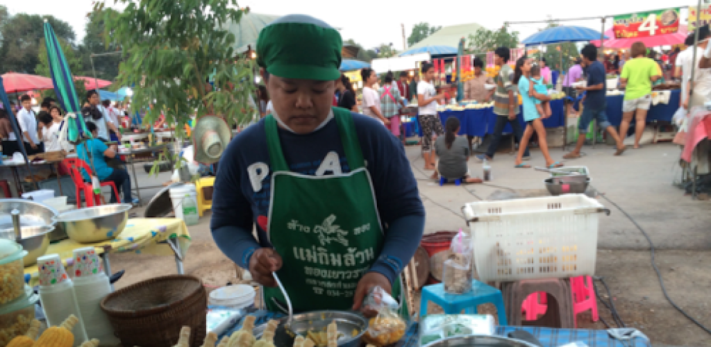 A woman cooks street-food in Thailand