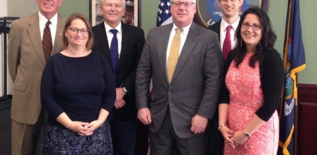 Four men and two women stand together for a photo