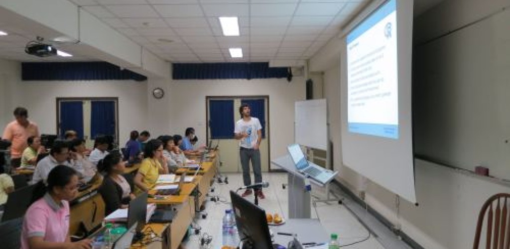 A man presents to a room full of people