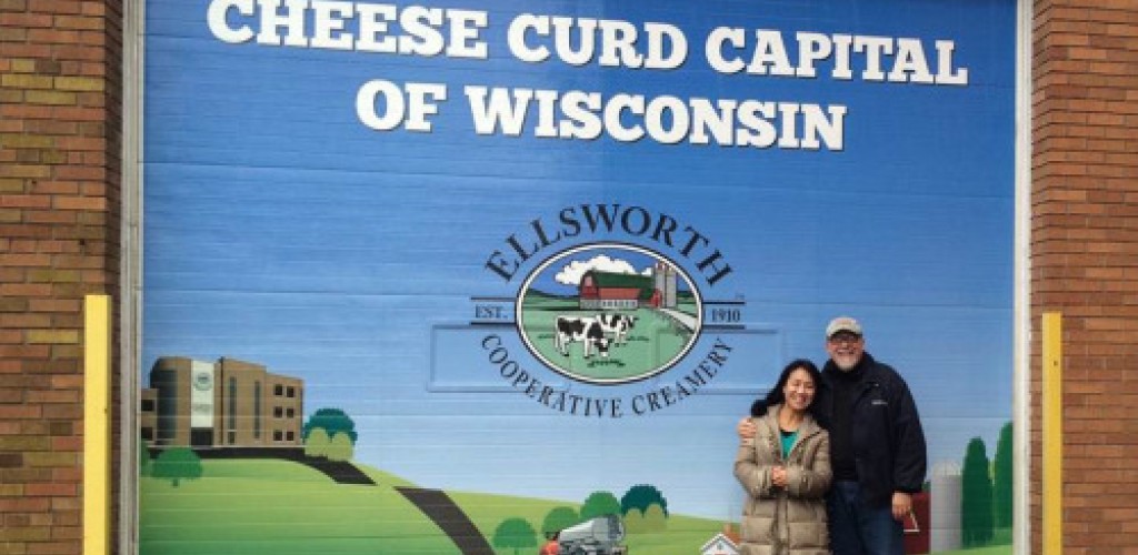 A woman and a man standing in front of a cheese curd advertisement