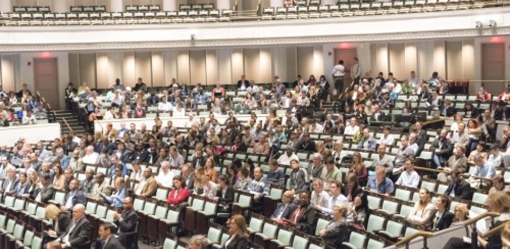 A group of people sitting in a lecture hall at a conference