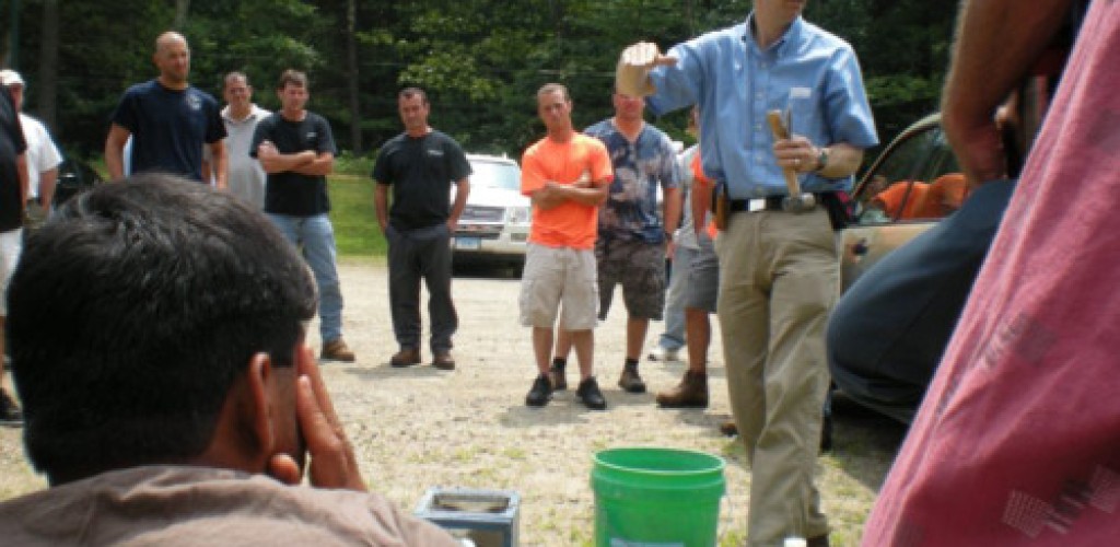A group listens to a man from the Cornell Local Roads Program speak