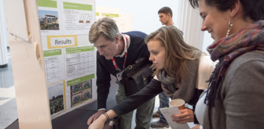 A group of people look at a poster board
