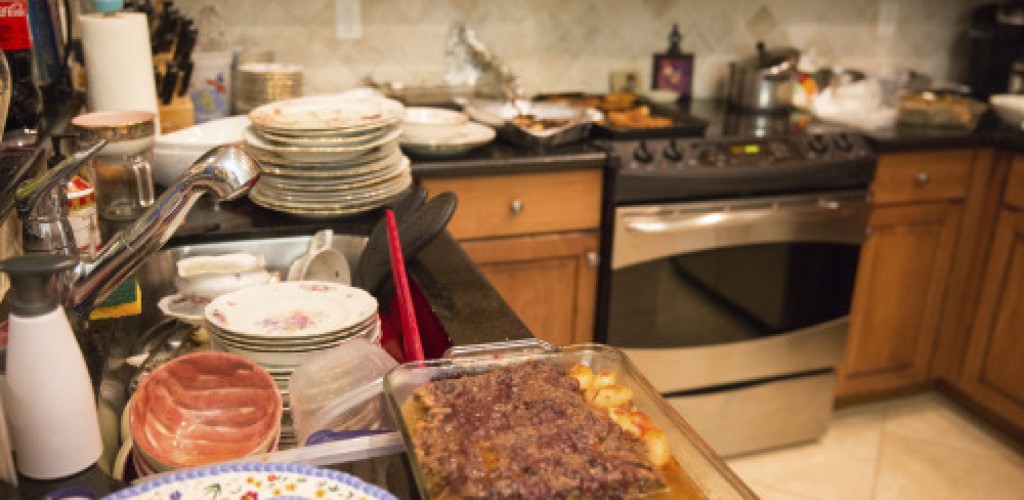 Cluttered kitchen with lots of dirty dishes on the counter