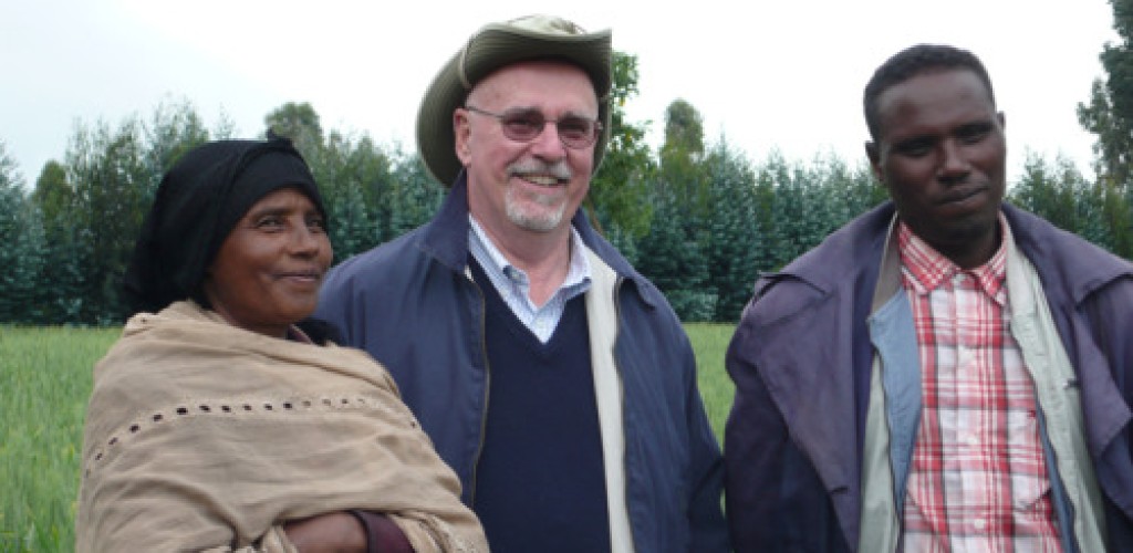 Two men and a woman stand in a field in Ethiopia