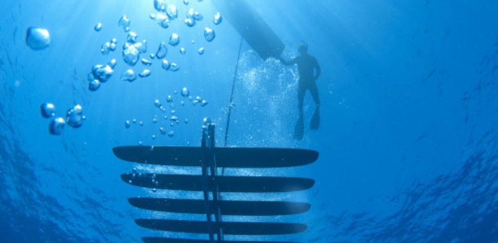 A person diving underwater with a robot used to collect acoustic data