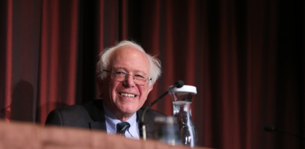 A man, Bernie Sanders, stands at a podium